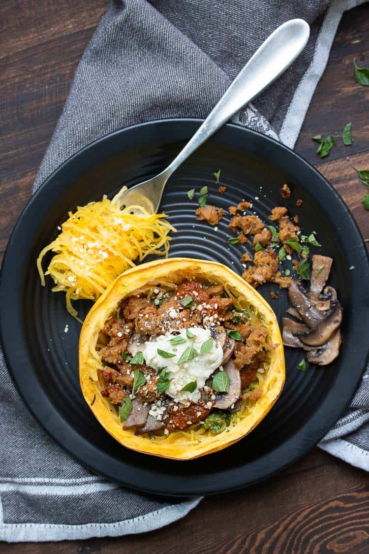 Baked spaghetti squash bowl with toppings on a black plate