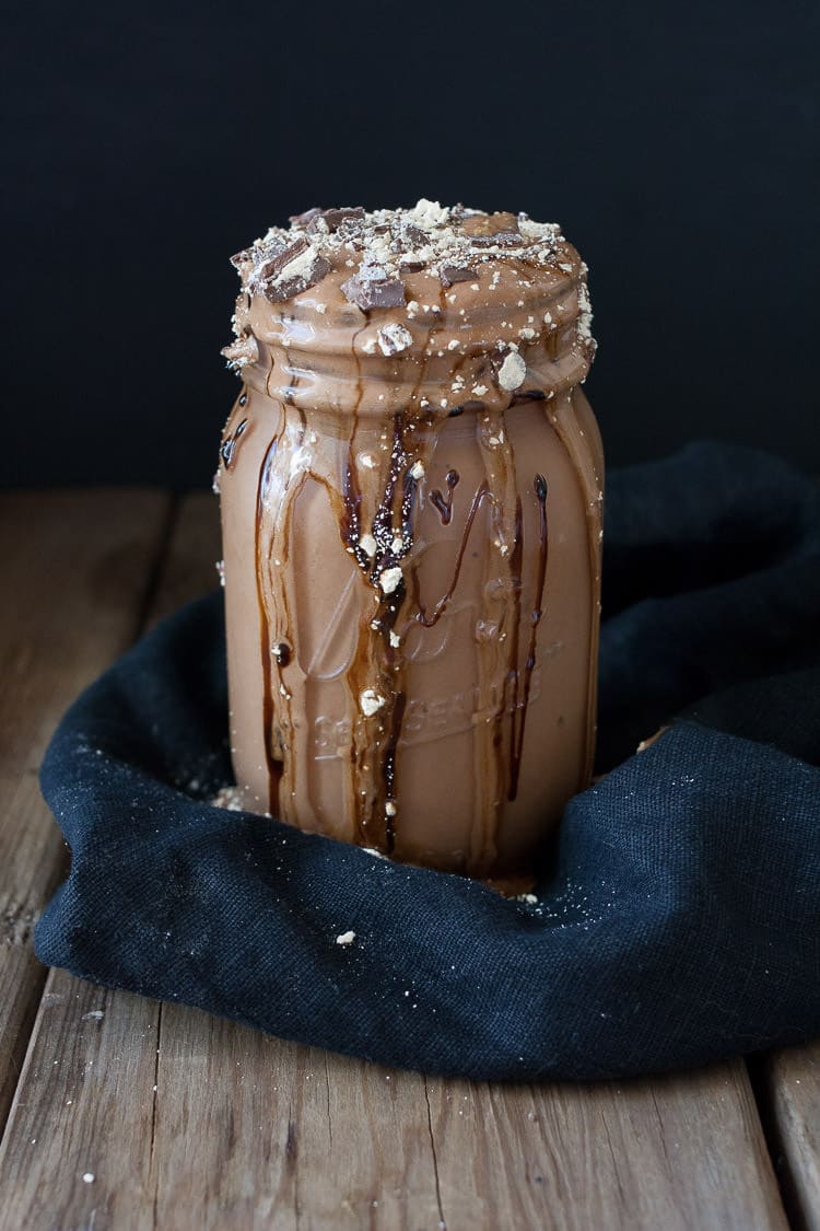 Vegan peanut butter cup milkshake in a glass jar with a dark background