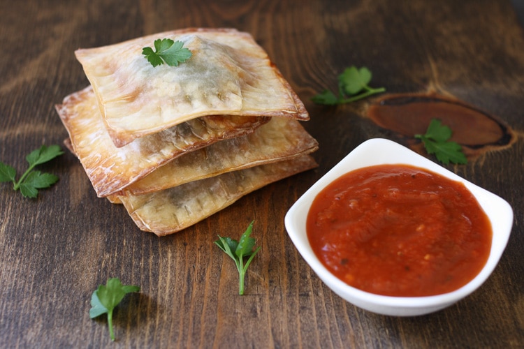 Lasagna filled wontons stacked on top of each other with dipping sauce