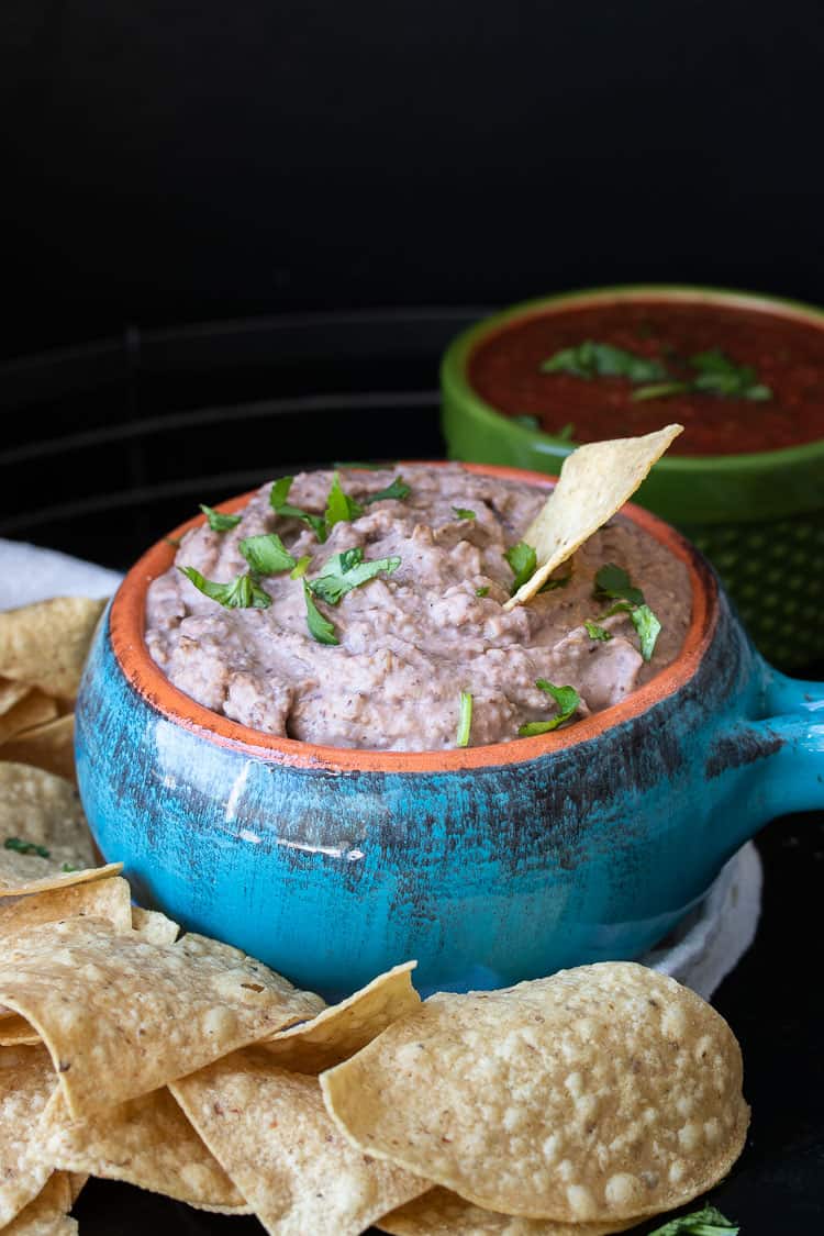 Turquoise bowl with chip dipping in bean dip