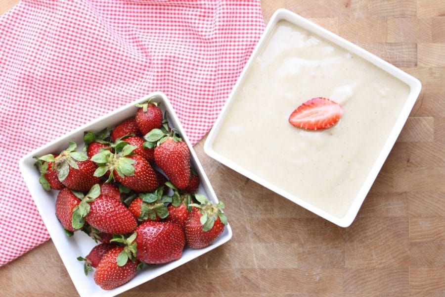 An overhead shot of a Vegan Date Yogurt Dip and a bowl of strawberries