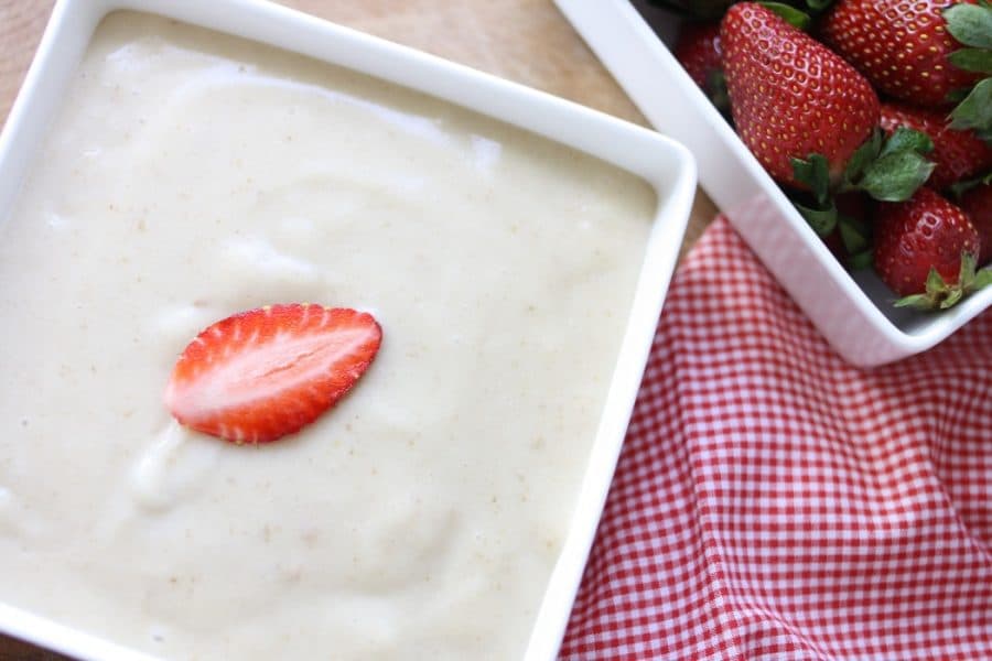 A close up of a Vegan Yogurt Dip topped with a strawberry