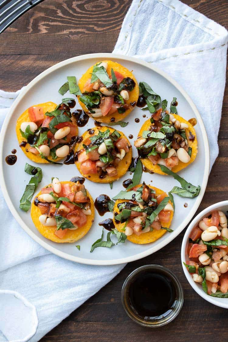 Rounds of baked polenta topped with tomato basil bruschetta