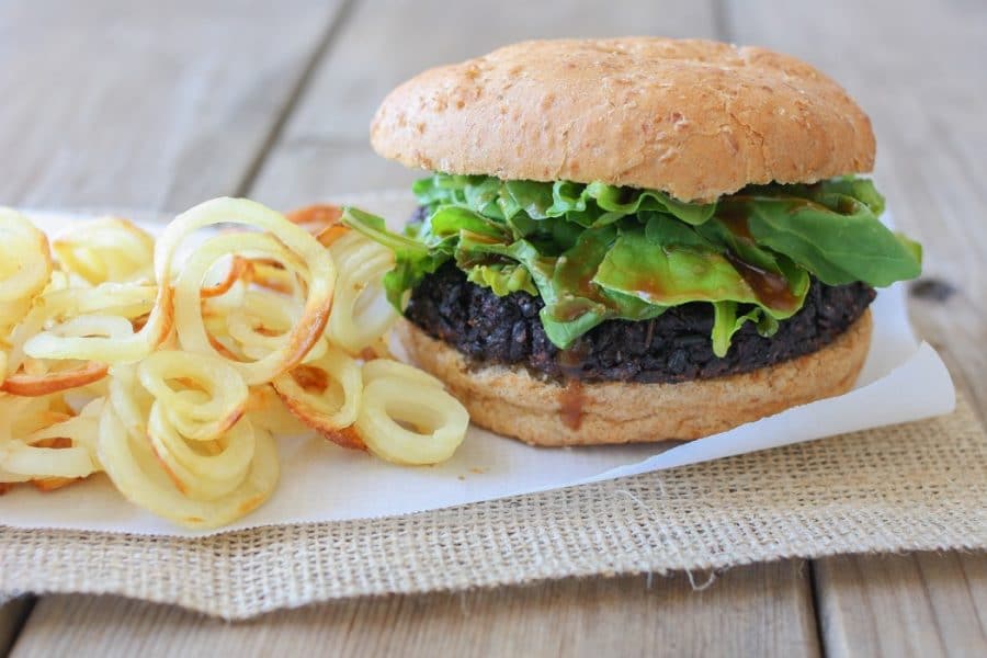 A close up of a black rice burger on a bun