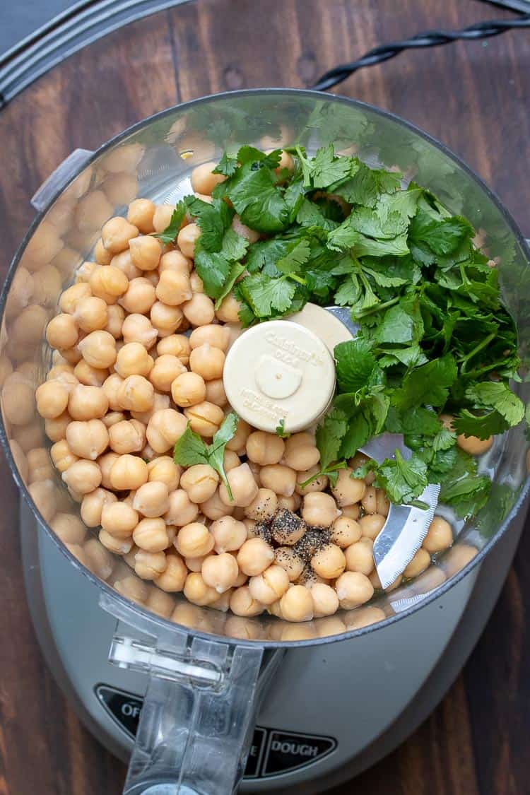 Food processor filled with chickpeas and parsley