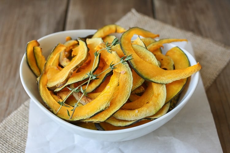 A close up of Baked Kabocha squash chips with thyme in a white bowl