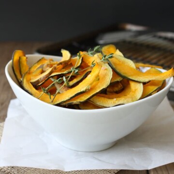 Baked Kabocha squash chips with thyme in a white bowl