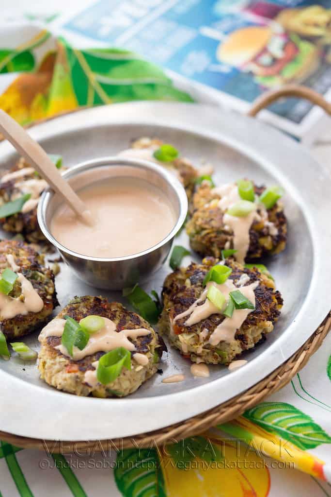 White plate with crab cakes and creamy sauce drizzle