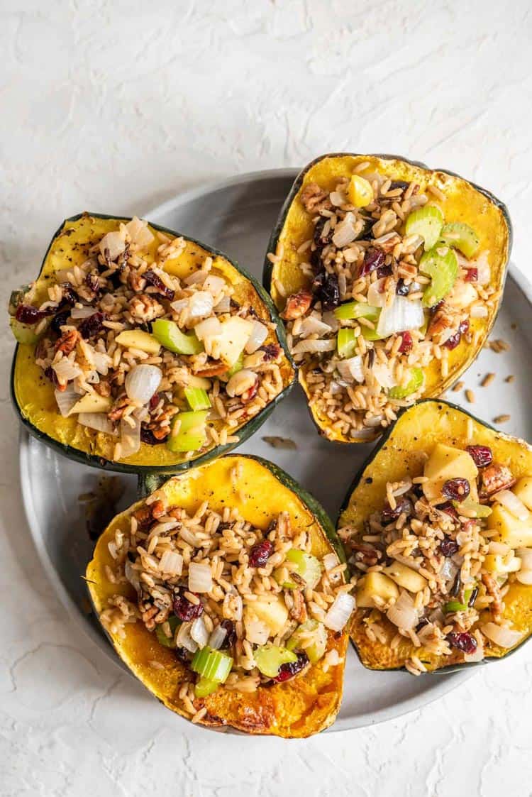 Plate of acorn squash cut in half and stuffed with a rice mixture