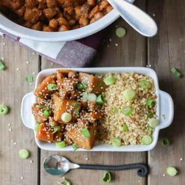 An overhead shot of a Korean Quinoa bowl with Chickpeas, Carrots & Potatoes on a wooden surface with a spoon