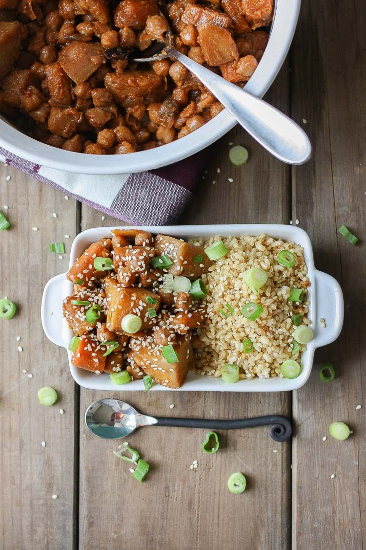 An overhead shot of a Korean Quinoa bowl with Chickpeas, Carrots & Potatoes on a wooden surface with a spoon