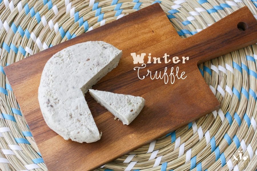 A winter truffle Miyoko's Creamery Vegan Cheese sitting on a wooden chopping board