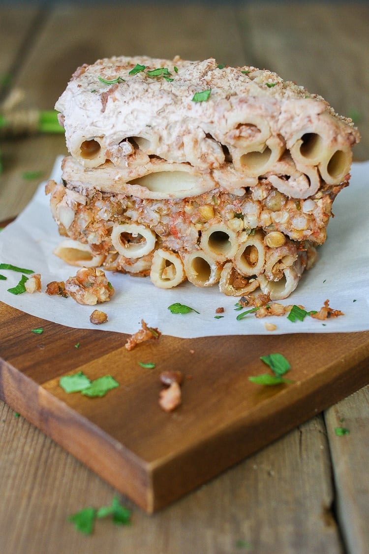 A slice of Vegan Greek Pastitsio on a wooden chopping board