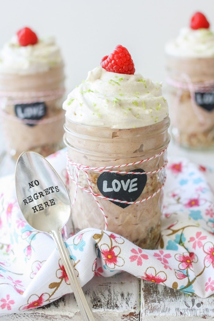 Key lime raspberry pudding parfaits in glass jars topped with a raspberry