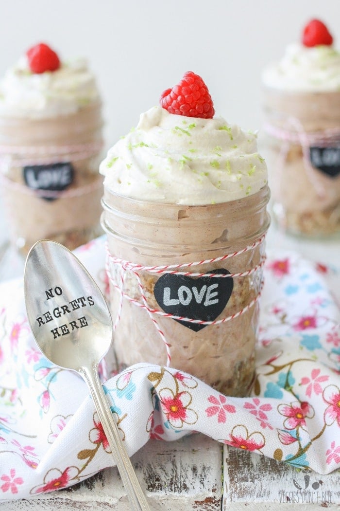 Key lime raspberry pudding parfaits in glass jars topped with a raspberry