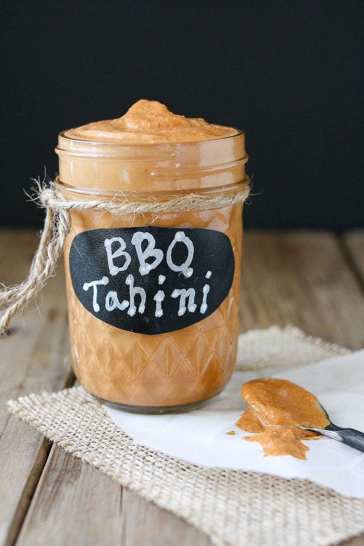 Barbecue tahini sauce in a glass jar with a black label with bbq tahini written