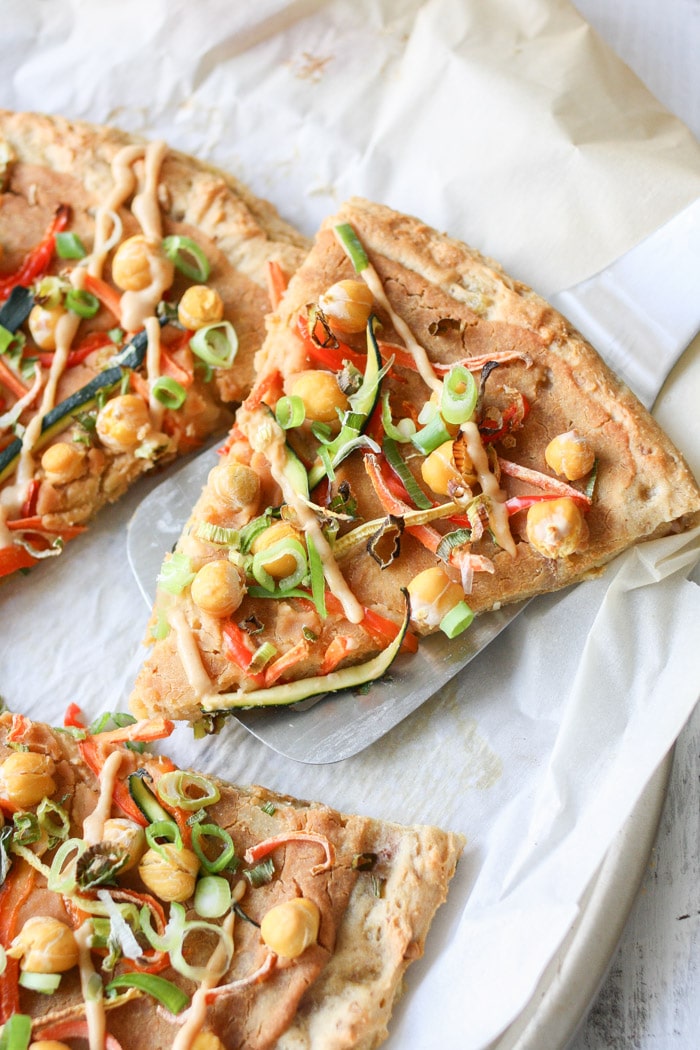 A close up of a slice of veggie pizza on a spatula