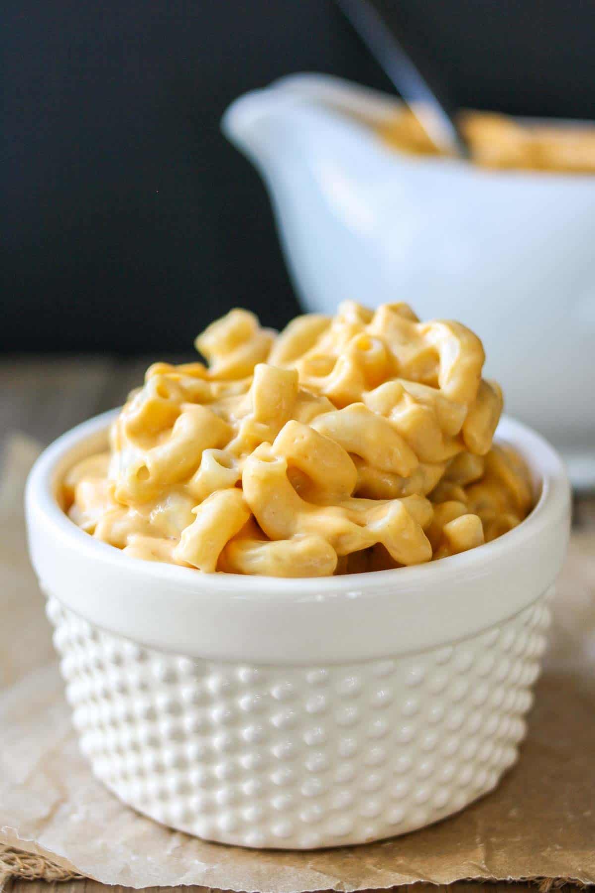 White textured bowl filled with creamy orange mac and cheese