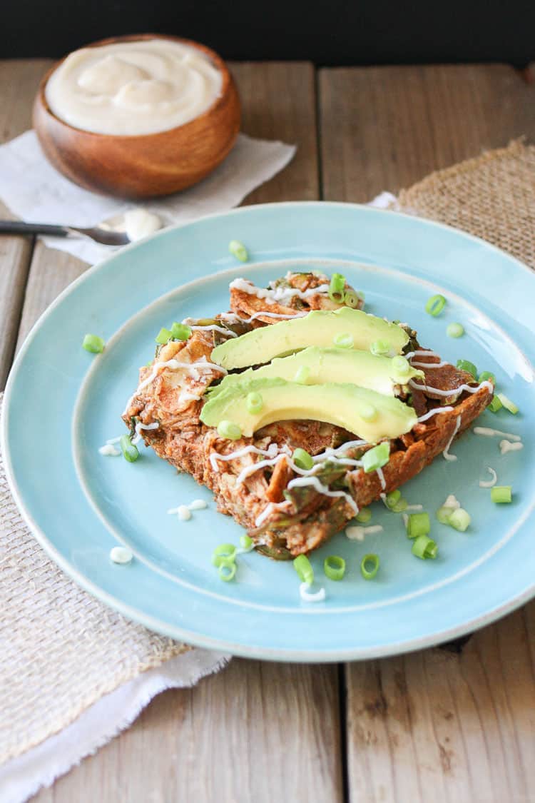 Vegan Enchilada Noodles Casserole on a blue plate topped with slices of avocado