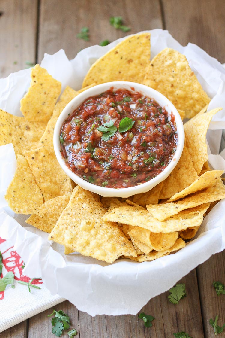 An overhead shot of Easy fresh Mexican Salsa in a small white bowl with chips at the side