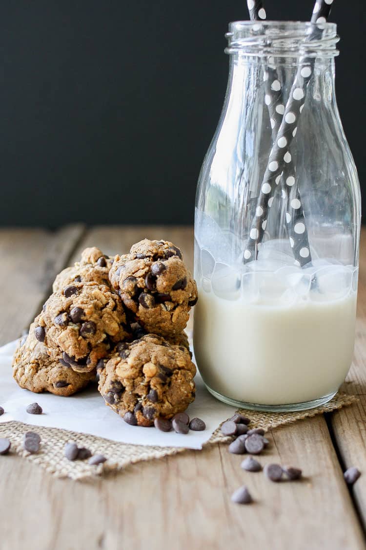 A small pile of Cookie Dough Balls‬‬‬‬‬‬‬‬‬‬‬ next to a glass of milk with straws