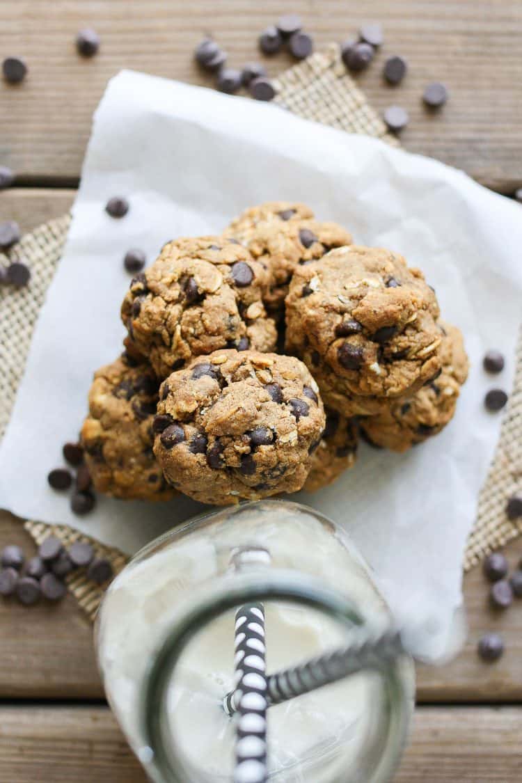 An overhead shot of Cookie Dough Balls‬‬‬‬‬‬‬‬‬‬‬ on a wooden surface with a glass of milk at the side