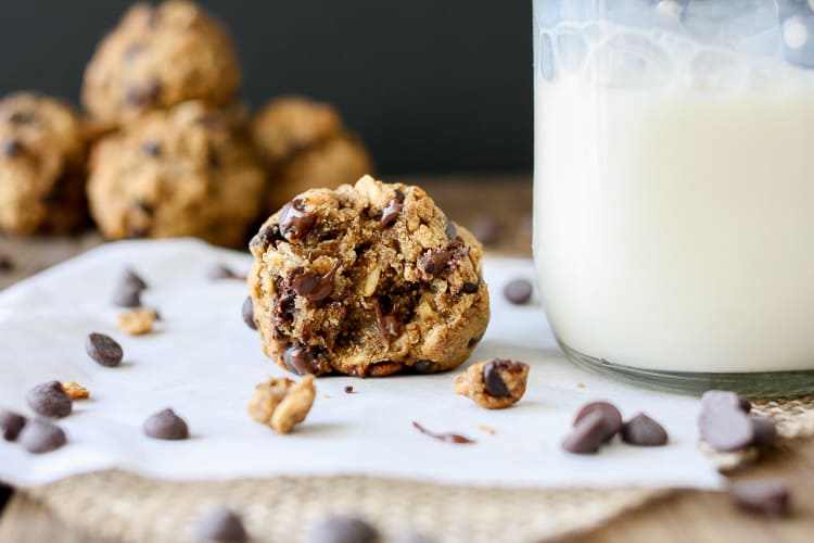 A close up of Cookie Dough Balls‬‬‬‬‬‬‬‬‬‬‬ with a bit out and chocolate chips scattered around