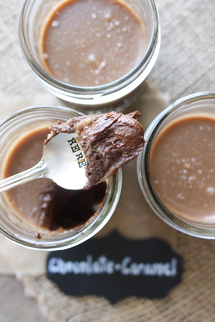 Three jars of chocolate protein pudding with a spoon scooping some out