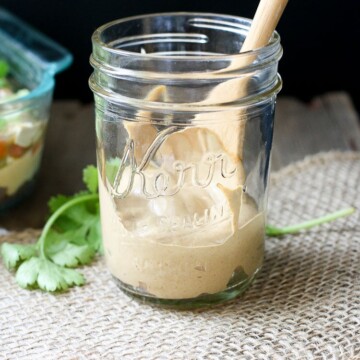 Creamy taco sauce in a jar with a wooden spoon