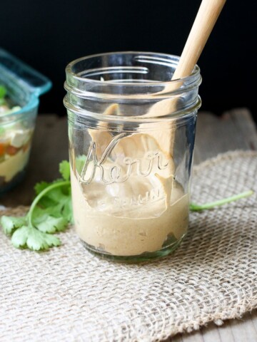 Creamy taco sauce in a jar with a wooden spoon