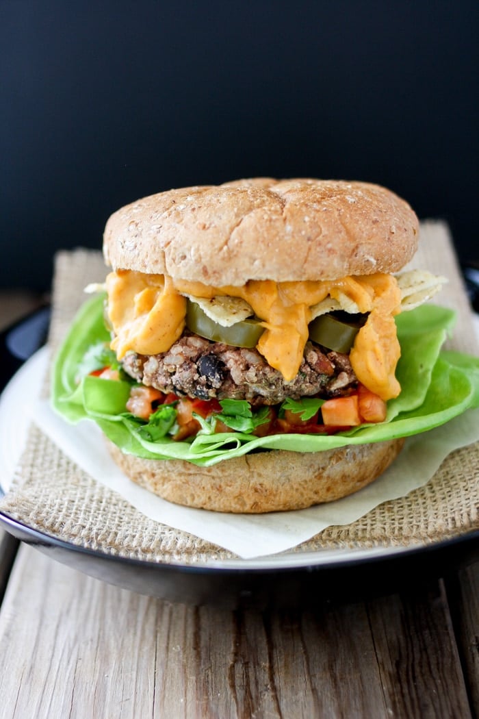 A photo of a Mexican nacho burger sitting on a plate