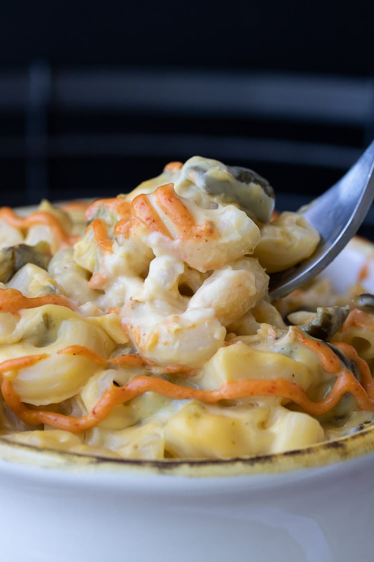 Close up of fork getting a scoop of mac and cheese with poblano peppers