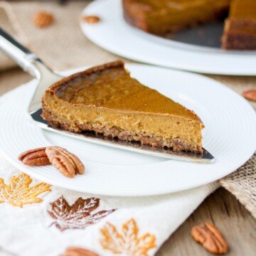 Front view of a slice of vegan pumpkin pie with pecan crust on a white plate