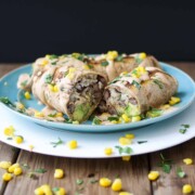 Vegan grilled burritos cut in half and sitting on a blue plate