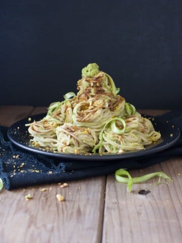 Vegan asparagus pesto over pasta sitting on a black plate