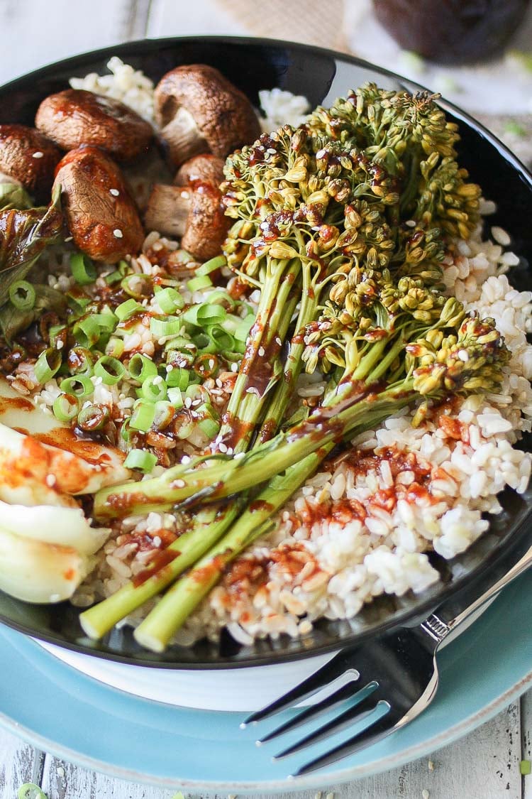 A close up of Teriyaki Rice Bowl with Roasted Veggies and drizzled with sauce