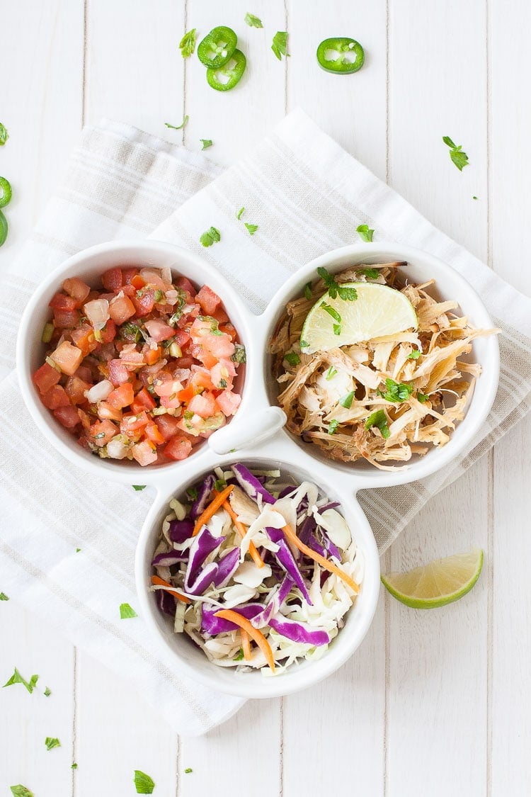 An overhead shot of three bowl filled with vegetables to make a vegan fish taco bowl