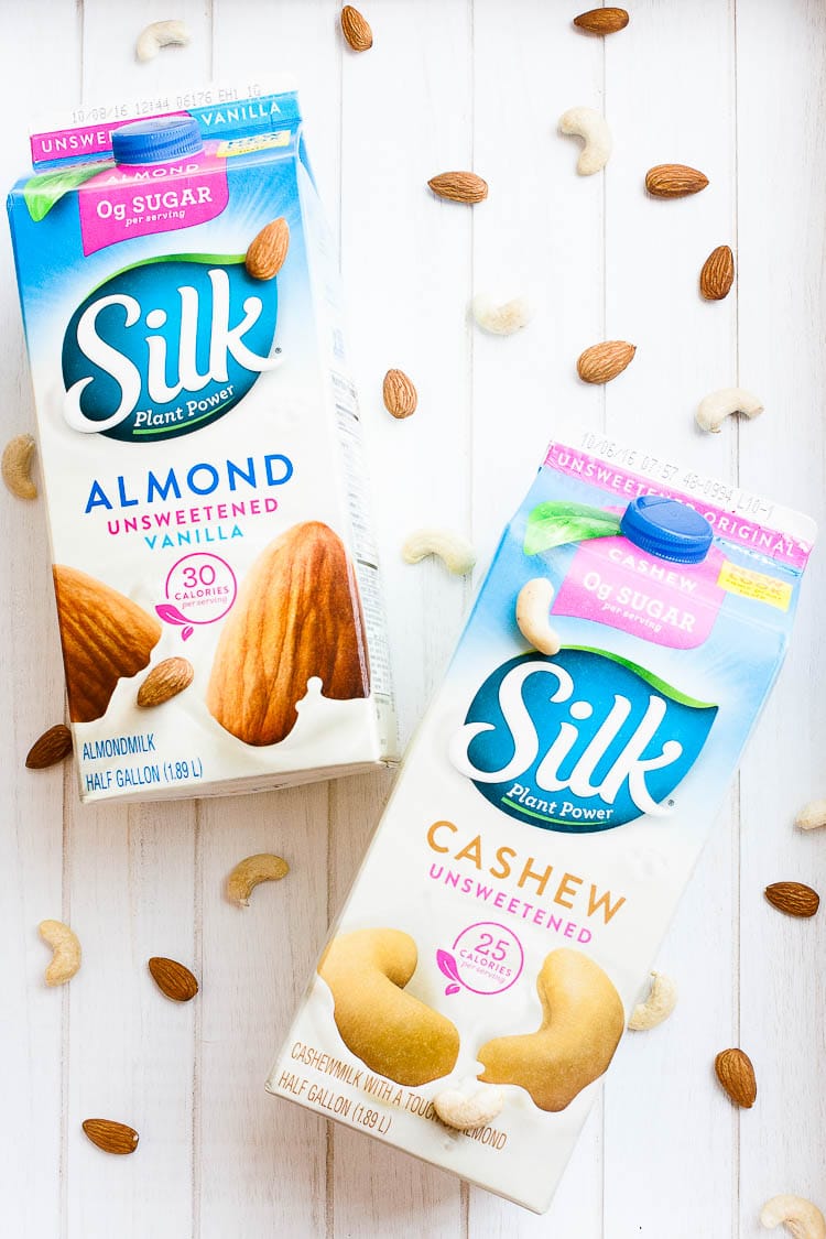 An overhead shot of colorful almond and cashew milk half gallon cartons