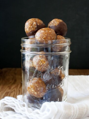 A glass jar filled with Raw Vegan Caramel Peanut Protein Truffles