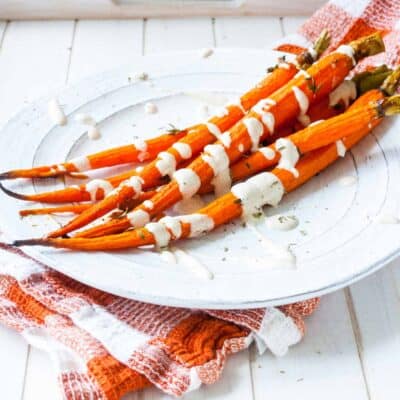 A side shot of smoky maple carrots on a white plate