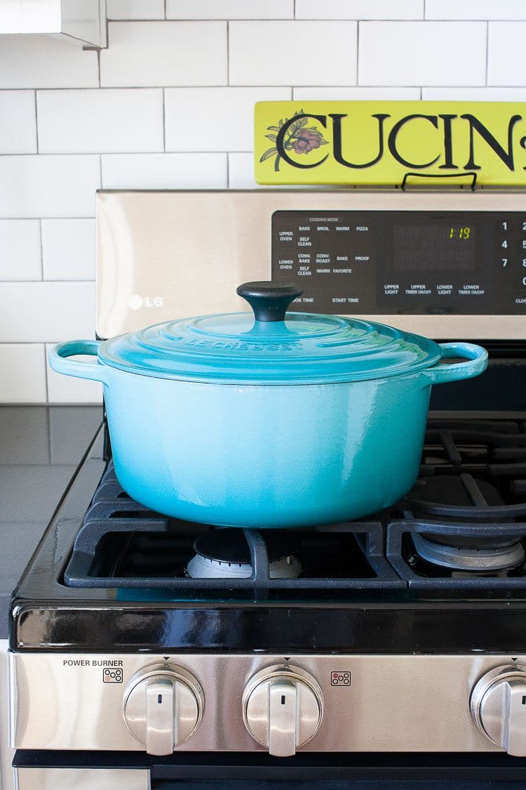 A blue pot sitting on a stove top to make a vegan Chickpea Soup