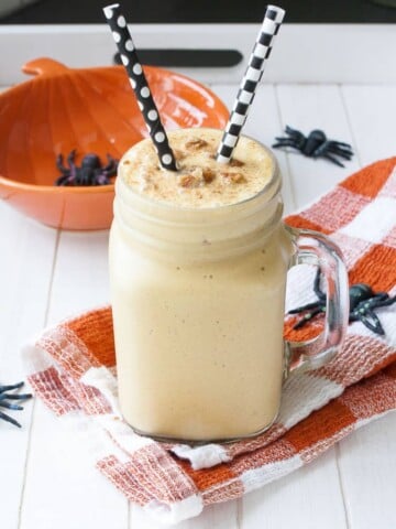 A Vegan Pecan Pumpkin Shake in glass jar with straws