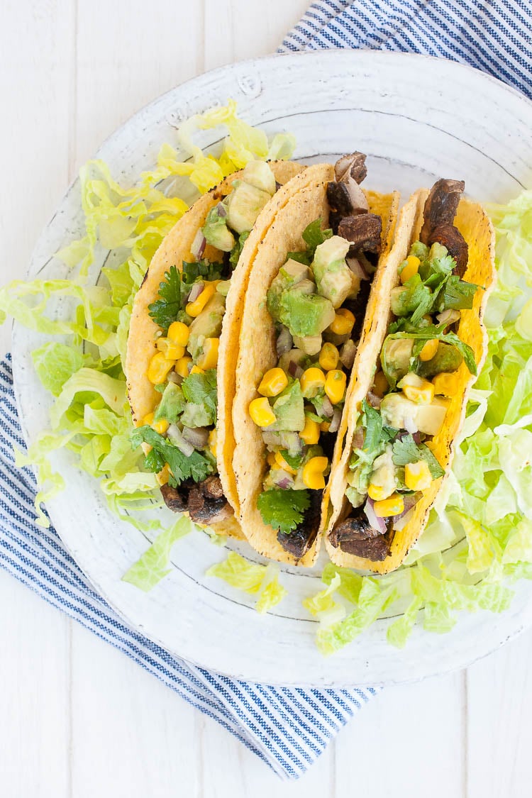 An overhead shot of Beer-Marinated Portobello Mushroom Tacos with salsa on a white plate