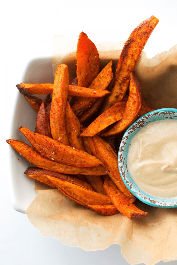 An overhead photo of sweet potato wedges with a dip