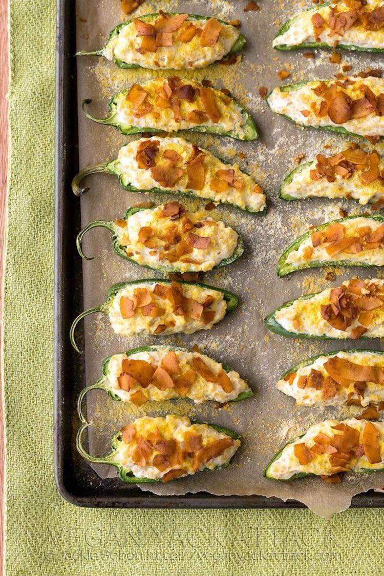 Cookie sheet filled with jalapeño poppers topped with coconut bacon pieces