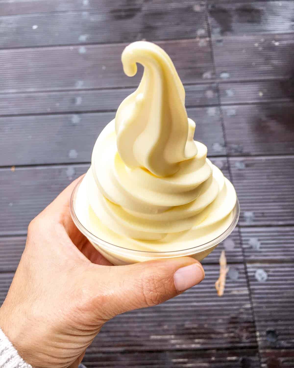 Hand holding a soft serve dole whip at Disneyland.