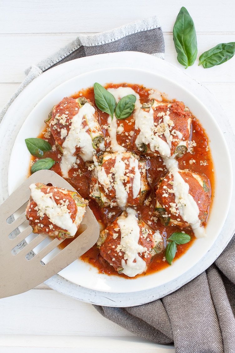 Vegan zucchini ravioli covered in tomato and cream sauce and topped with basil and parmesan