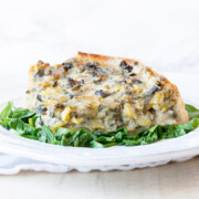 Spinach pie on a white plate on a bed of sautéed spinach