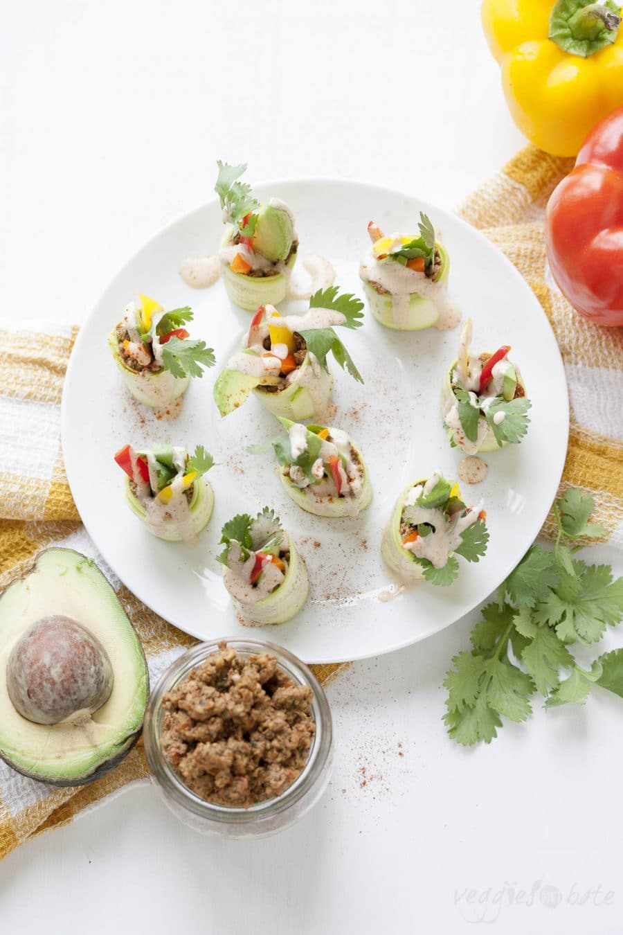 A raw appetizer of veggies and a raw walnut "meat" rolled up with raw sliced zucchini