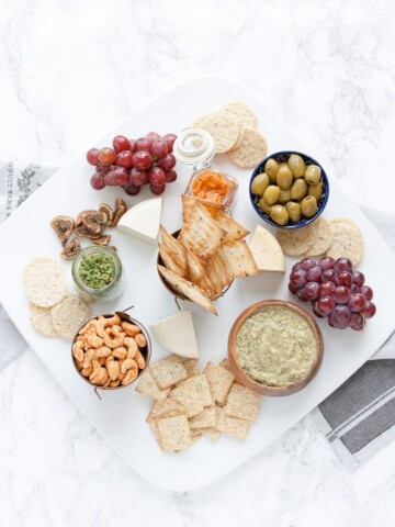 An overhead shot of a vegan cheese and dip platter on a marble surface